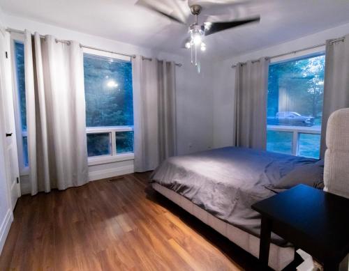 una camera con un letto e due finestre di Entire Luxurious Waterfront Peninsula Cottage - 7 Bedroom with Hottub a Marmora