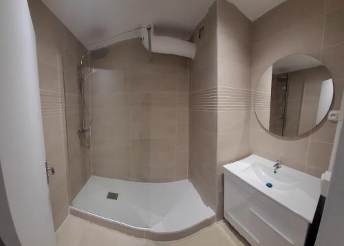 une salle de bain avec une douche, un lavabo et un miroir dans l'établissement Grand appartement avec parking privé, à Épinay-sur-Seine