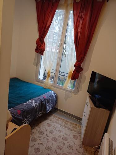 Schlafzimmer mit einem Bett und einem Fenster mit roten Vorhängen in der Unterkunft Ivone guest in Maisons-Alfort