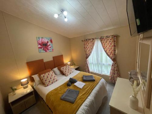 a bedroom with a bed with towels on it at Luxury Lakeside Lodge L2 with Hot tub situated at Tattershall Lakes Country Park in Tattershall