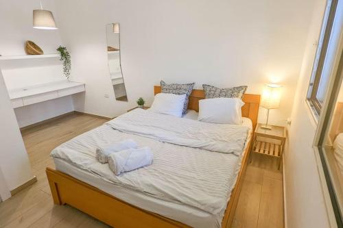 ein Schlafzimmer mit einem großen Bett mit weißer Bettwäsche und Kissen in der Unterkunft Charming unit in Dead Sea in Ovnat