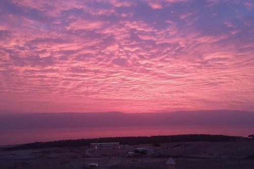 a sunset over the ocean with a pink at Charming unit in Dead Sea in Ovnat