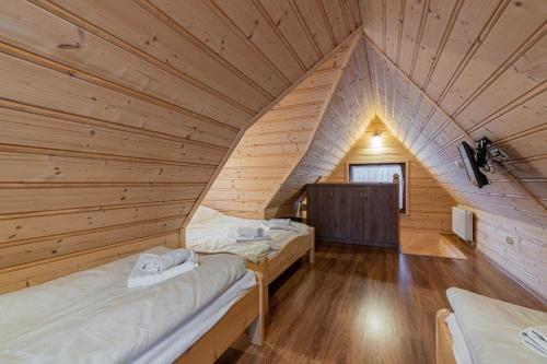 a room with two beds in a log cabin at Widokowe Domki Gawlaki in Zakopane