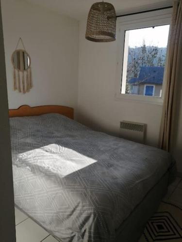 une chambre avec un lit et une fenêtre dans l'établissement Appartement calme et propre Le Goelia, à Saint-Geniez-dʼOlt