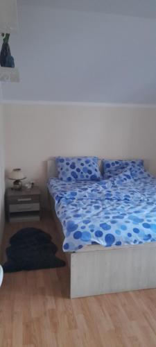 a bedroom with a bed with a blue comforter at Vila Marina in Kovin