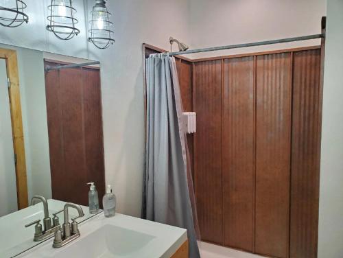 uma casa de banho com um chuveiro, um lavatório e um espelho. em Lazy Bear Ranch em Weiser