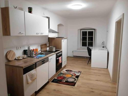 a kitchen with white cabinets and a wooden floor at Ganzes Appartement in Seitenstetten in Seitenstetten Markt