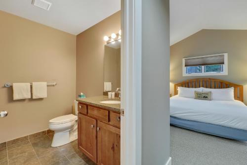 a bedroom with a bed and a toilet and a sink at 728 Disciples Village Condo in Boyne Falls