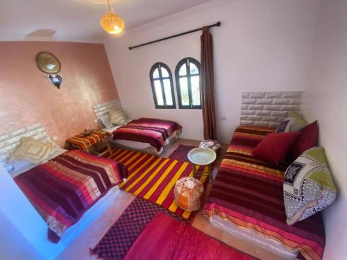 a living room with two beds and a couch at Auberge Tissadrine in Akhendachou nʼAït Ouffi