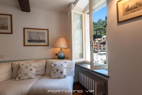 een woonkamer met een bank en een groot raam bij Casa Smeraldo by PortofinoVip in Portofino
