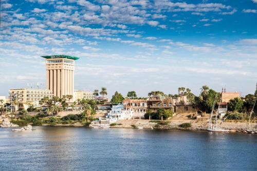 a view of a river with buildings and a tower at Mövenpick Resort Aswan in Aswan
