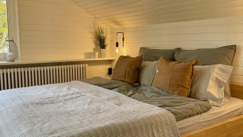 Cama en habitación con almohadas en Quiet 2 room garden loft with terrace, en Bad Tölz