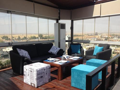 a living room with couches and a table at Fiori Hotel in Erbil