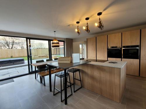 a kitchen with a island and a table with chairs at Lindum Barn, Ashlin Farm Barns in Lincoln