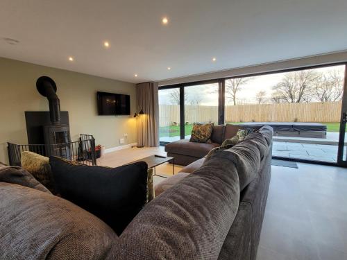 a living room with a couch and a fireplace at Lindum Barn, Ashlin Farm Barns in Lincoln