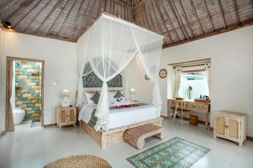 - une chambre avec un lit à baldaquin dans l'établissement Amaya Sebatu Villa, à Ubud