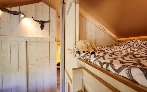 a room with a bed with a cow skull on it at Camping Vossenberg - op de Veluwe! in Epe