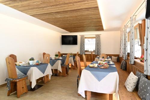 a dining room with two tables and a tv at Mas dei Masi in Cavalese