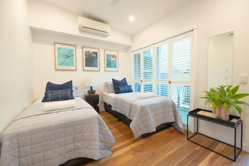 拜倫灣的住宿－Swell Byron Bay - Opposite the Belongil Beach，一间卧室设有两张床和窗户。