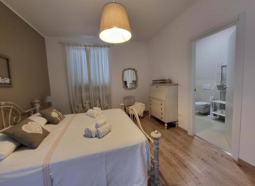 a bedroom with a white bed and a bathroom at Villa Lida Apartment in collina con ampio terrazzo vista mare in Giulianova