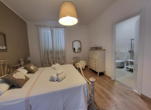 a bedroom with a white bed and a bathroom at Villa Lida Apartment, in collina con ampio terrazzo e vista mare in Giulianova