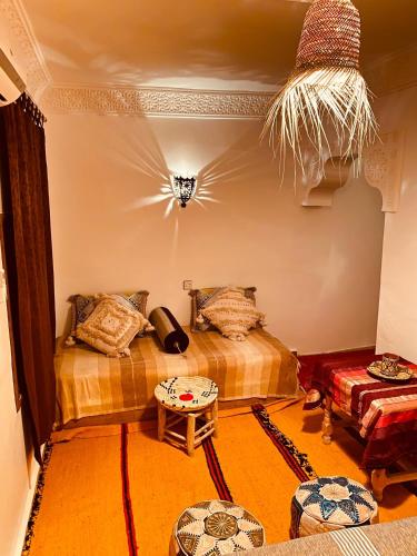 a room with two beds and a table in a room at Auberge Tissadrine in Akhendachou nʼAït Ouffi
