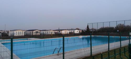 uma grande piscina com uma cerca em redor em Blauwe Lagune em De Haan