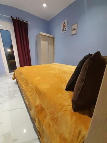 a bedroom with a bed with a yellow blanket at Salavantinas House in Tavronitis