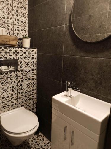 a bathroom with a toilet and a sink and a mirror at Studio Sunset in Voždovac