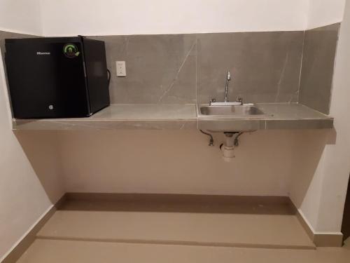 a bathroom with a sink and a microwave at Apartamento in Bacalar