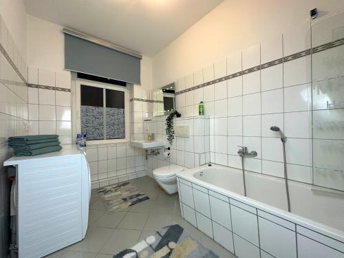 uma casa de banho branca com uma banheira e um WC em Stilvolle, charmante Ferienwohnung in Plauen em Plauen