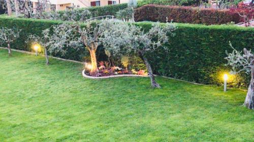 a group of people sitting in a garden at night at LHV Garda Lake - Private POOL and SPA in Bardolino