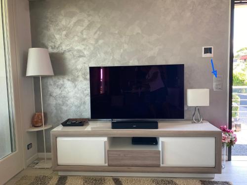 a living room with a flat screen tv on a entertainment center at LHV Garda Lake - Private POOL and SPA in Bardolino