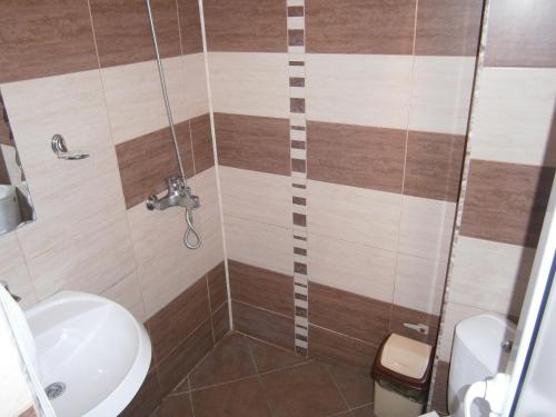 a bathroom with a shower with a sink and a toilet at Morska Zvezda Guest house in Pomorie