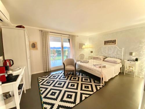 a white bedroom with a bed and a table and a chair at LHV Garda Lake - Private POOL and SPA in Bardolino