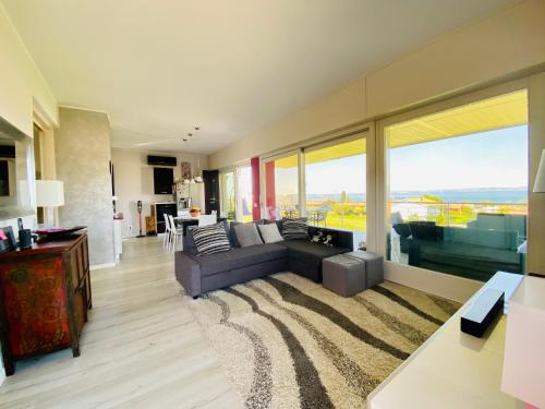 a living room with a couch and a large window at LHV Garda Lake - Private POOL and SPA in Bardolino