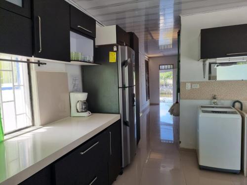 eine Küche mit schwarzen Schränken und einem Kühlschrank in der Unterkunft PLAYABRISAMAR in San Antero