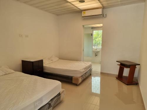 a room with two beds and a table in it at PLAYABRISAMAR in San Antero
