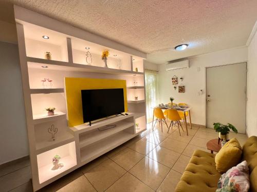 sala de estar con TV y mesa en Departamento planta baja en Acapulco Diamante, en Acapulco