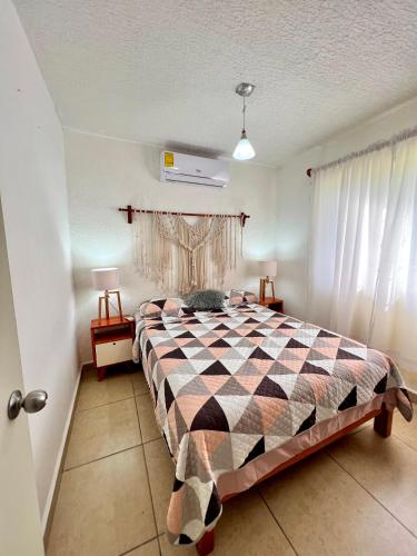 a bedroom with a bed with a checkered blanket at Departamento planta baja en Acapulco Diamante in Acapulco