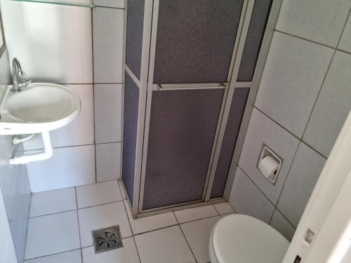 a bathroom with a shower and a toilet and a sink at APTO CENTRO GUARAPARI in Guarapari