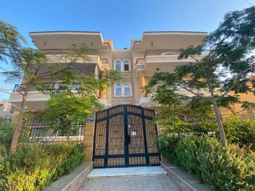 brama przed budynkiem z drzewami w obiekcie New Cairo lux apt in lux villa basement1 w Kairze