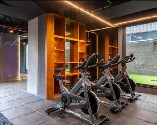 un gimnasio con 3 bicicletas estáticas en una habitación en EXCLUSIVO APARTAESTUDIO USAQUEN, en Bogotá