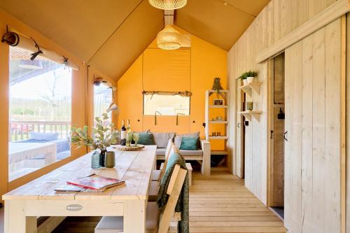 a room with a table and chairs in a house at Camping Vossenberg - op de Veluwe! in Epe