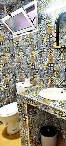 a bathroom with two toilets and a tile wall at Tigmi surf morocco in Tiguemmi nʼAït Bihi