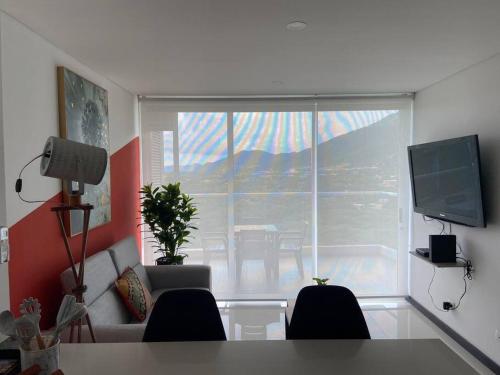 a living room with a couch and a large window at Modern well-equipped 4 PPL condo/5 MIN beach walk in Santa Marta