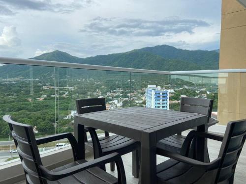 a table and chairs on a balcony with a view at Modern well-equipped 4 PPL condo/5 MIN beach walk in Santa Marta
