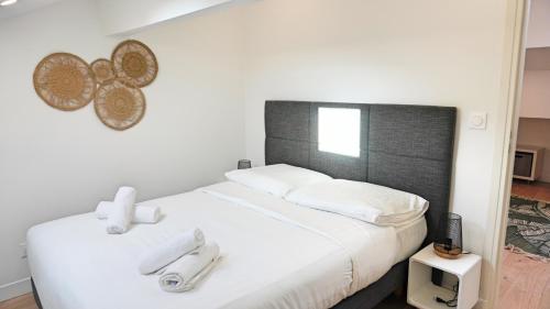 - une chambre avec un lit blanc et une tête de lit noire dans l'établissement Proche Carlton & Croisette, Appartement 401 - Palmazur Vacances, à Cannes