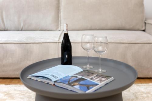 a table with a bottle of wine and two wine glasses at Spacious Apartment with Swimming Pool, Gym and Sauna WWA40 in Warsaw