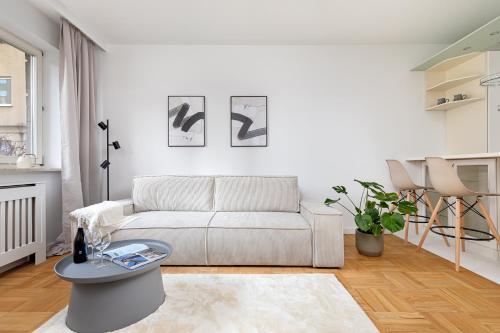 a white living room with a couch and a table at Spacious Apartment with Swimming Pool, Gym and Sauna WWA40 in Warsaw